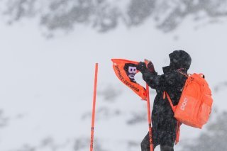 Un volontaire s'active sur la piste de la Gran Becca pour enlever un portillon après l'annulation de l'entraînement de jeudi